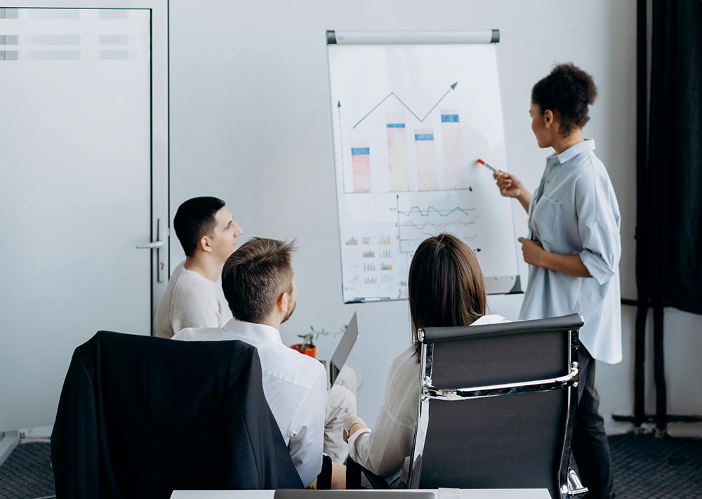 Group of people in a meeting going over charts